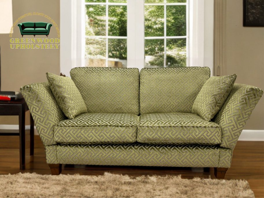 Green polka dot sofa with three cushions, set near a window.